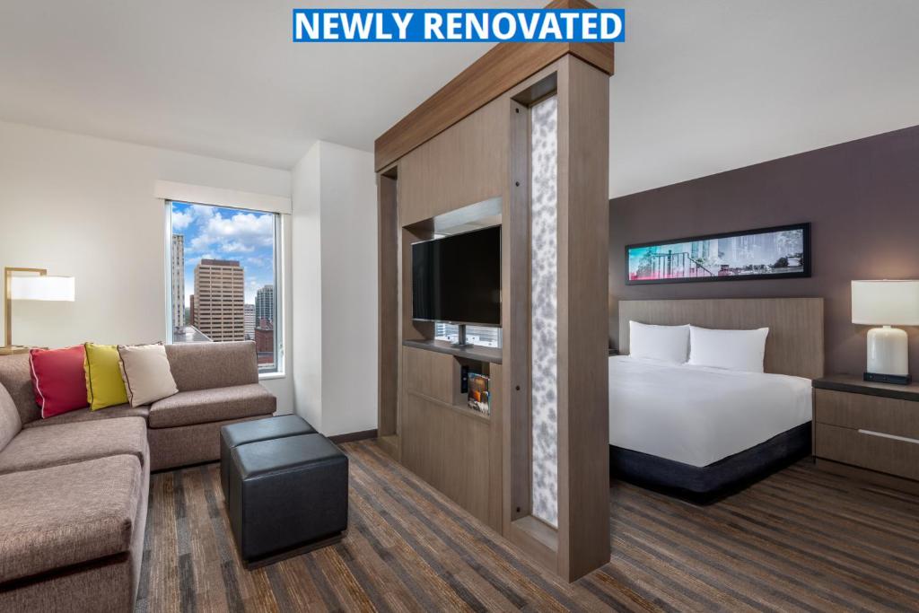 a hotel room with a bed and a couch at Hyatt House Denver Downtown in Denver