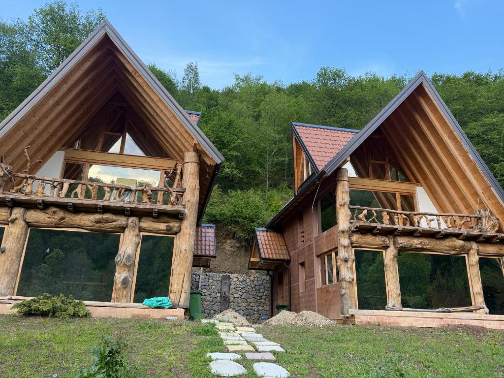a log home with two large windows and a balcony at Etno selo Vukovic Bijelo Polje in Bijelo Polje