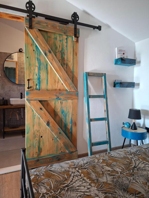 a sliding barn door in a bedroom with a bed at MARANGUN Drage apartman in Drage
