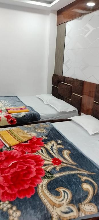 two beds in a room with a carpet on the floor at Hotel Shree shivay omkareshwar in Godarpura