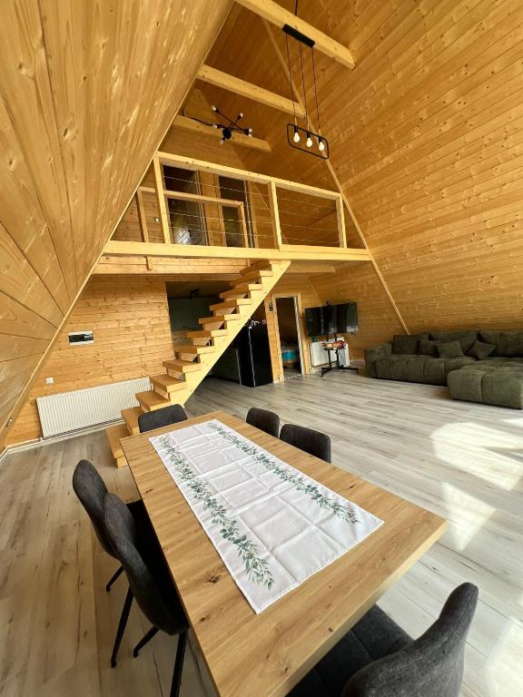 a large room with a wooden table and chairs at Crow`s Nest Murmur Măguri in Măguri