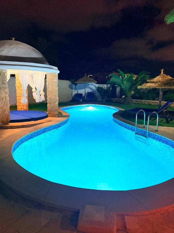 a swimming pool at night with a gazebo at Houch Taguermess in Taguermess