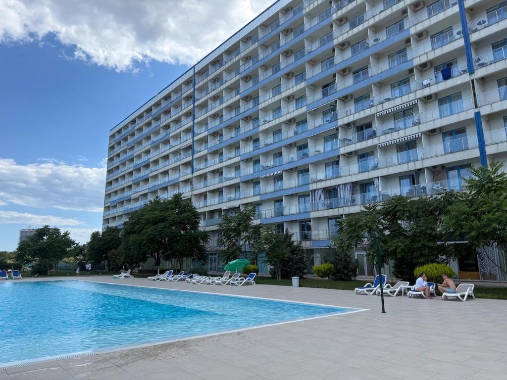 a large building with a swimming pool in front of it at Blaxy del Mar Studio Olimp in Olimp