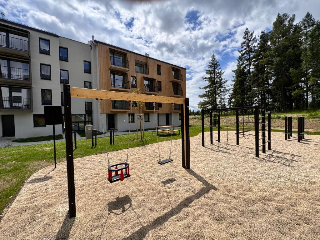 an empty playground in front of a building at Apartment Tatry Gerlachov, Vysoke Tatry in Svätý Jur