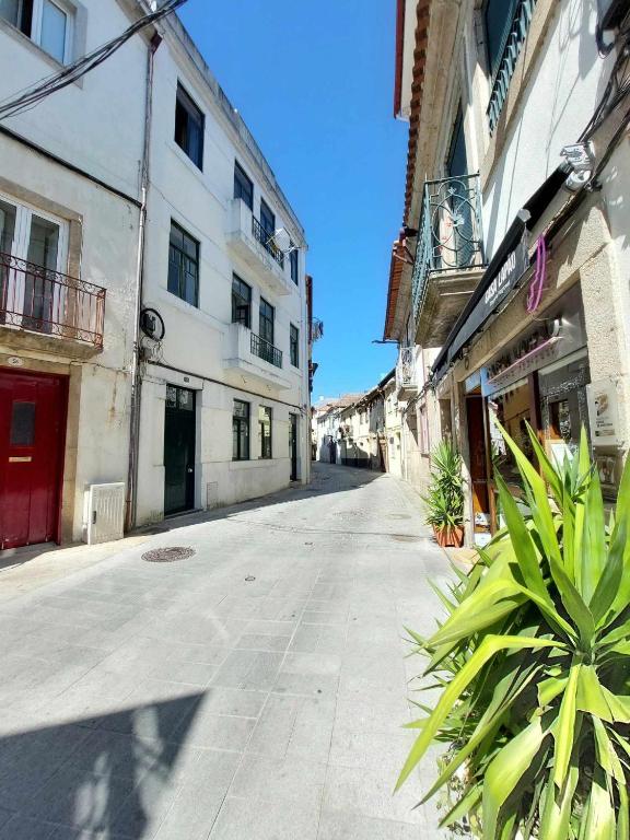 an empty street in a city with buildings at Historic Downtown II in Vila Real
