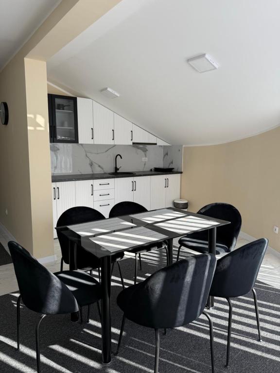 a dining room with a black table and chairs at Vivko apartmani 2 in Ostrovo
