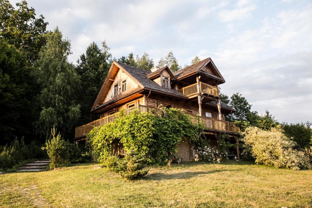 a large wooden house on a grass field at Siódmy Las in Zawada
