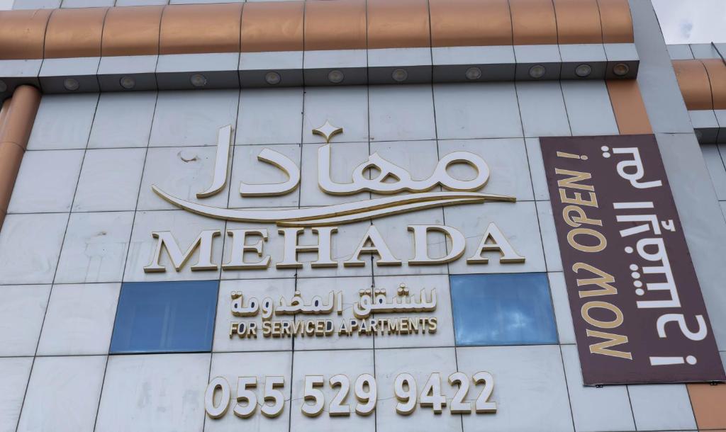 a sign on the side of a building at مـهادا Mehada in Taif
