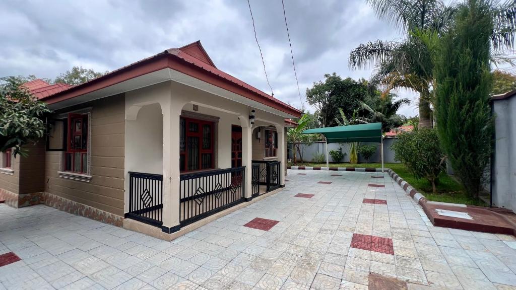 a small house with a courtyard in front of it at Jubilant Experience Homes Arusha in Arusha