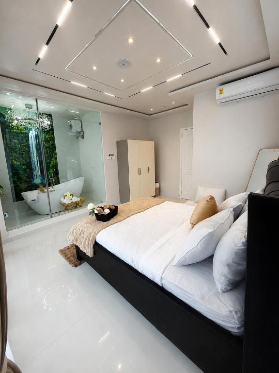 a bedroom with a large bed and a bath tub at One Plus One Luxe Retreat with Airport Pickups in Sakumona