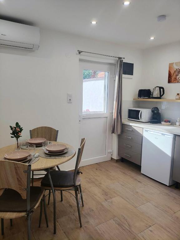 a kitchen and dining room with a table and chairs at B30 Apartmanok, Eger in Eger