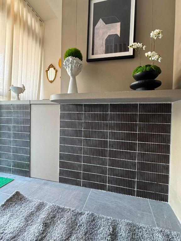 ein Zimmer mit einer gefliesten Theke, auf der Vasen stehen in der Unterkunft Dreamloft Hotel in Singapur