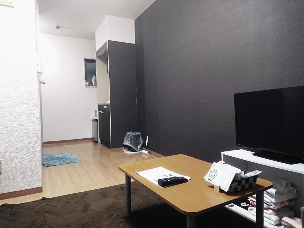 a living room with a table and a flat screen tv at Sora / Vacation STAY 1124 in Sakai