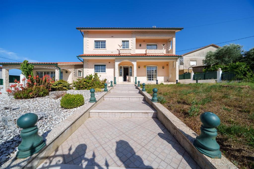 a large house with a walkway in front of it at Família de Arega in Arega