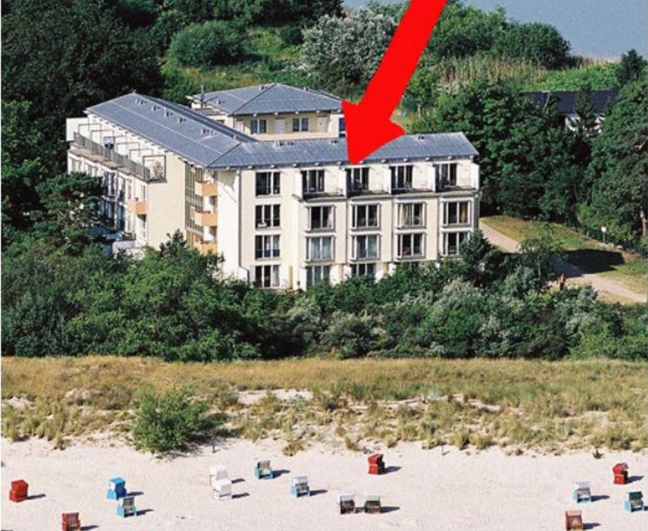 a large building on a beach with a red arrow at Forum Marinar 38 in Bansin