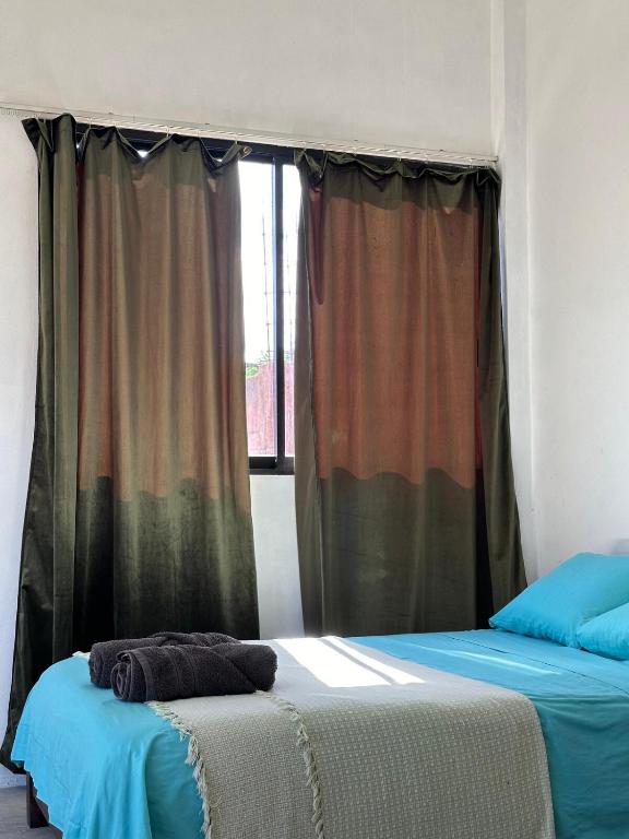 two beds in a room with a window at Casa roja Depto A in Palenque