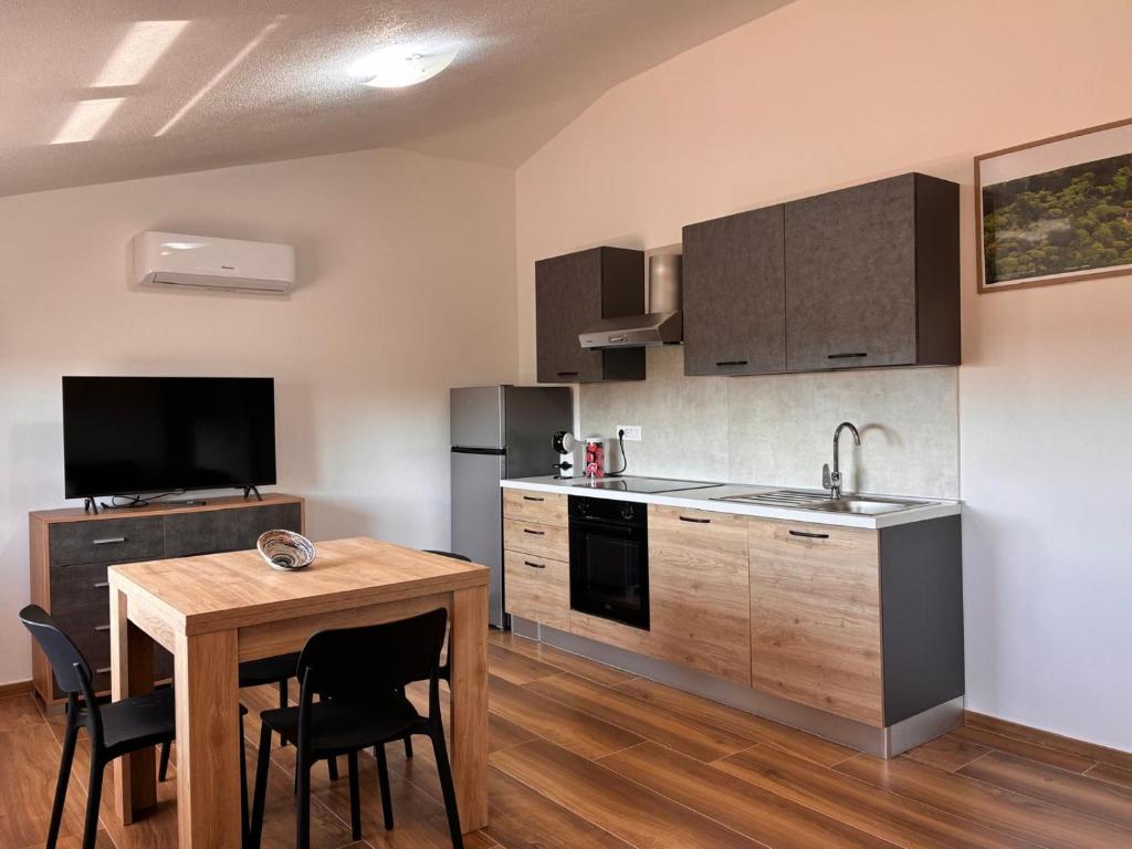 a kitchen with a wooden table and a small dining room at Casa Demelas in Stintino