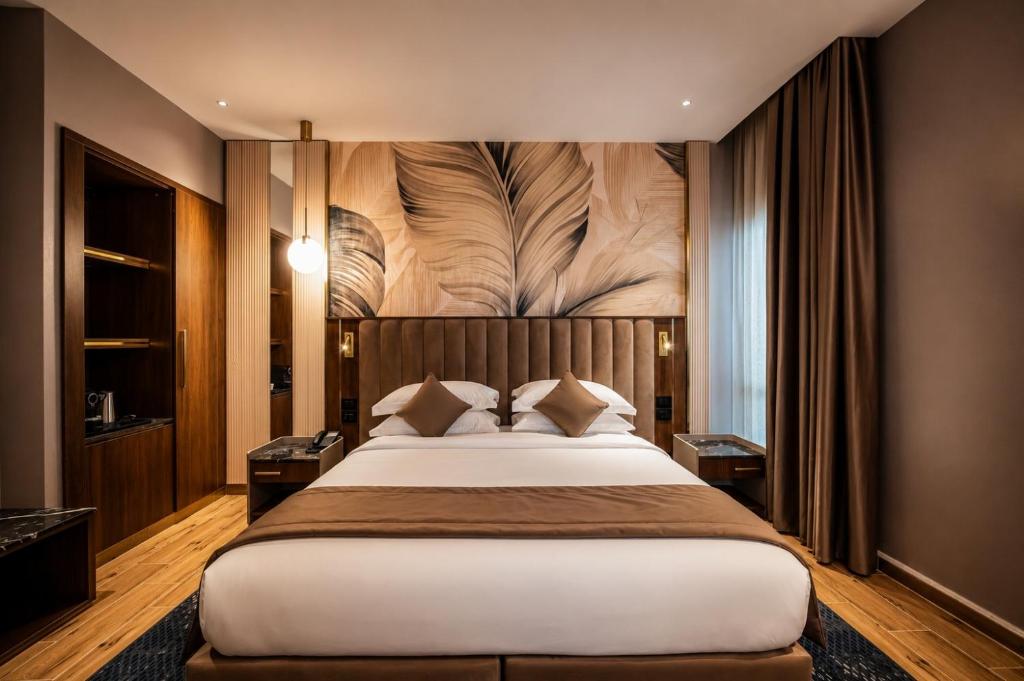 a bedroom with a large bed with a wooden headboard at Hotel Supreme in El Biar