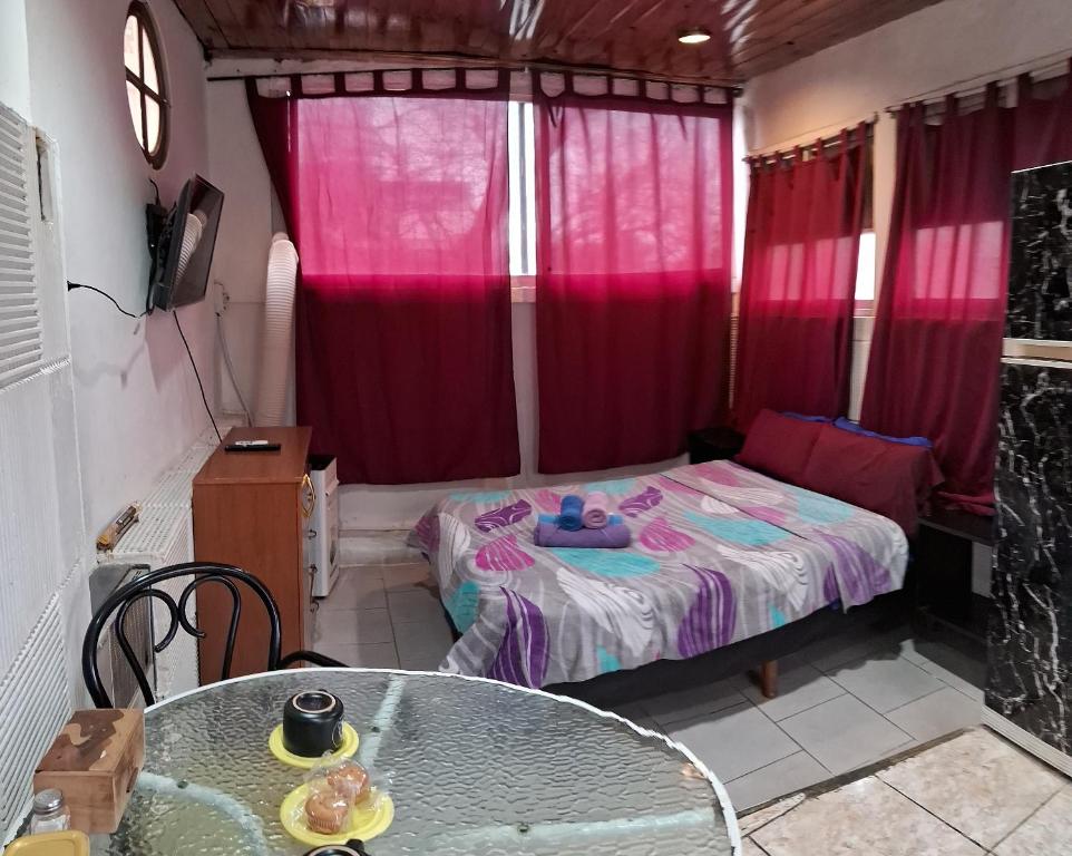 a room with a table and a bed with red curtains at Che Lolita house 4 in Buenos Aires