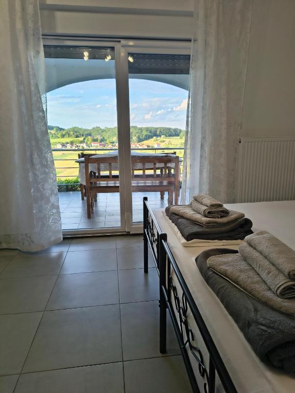 two beds in a room with a view of a balcony at Studio apartman Tilia in Veliko Trgovišće