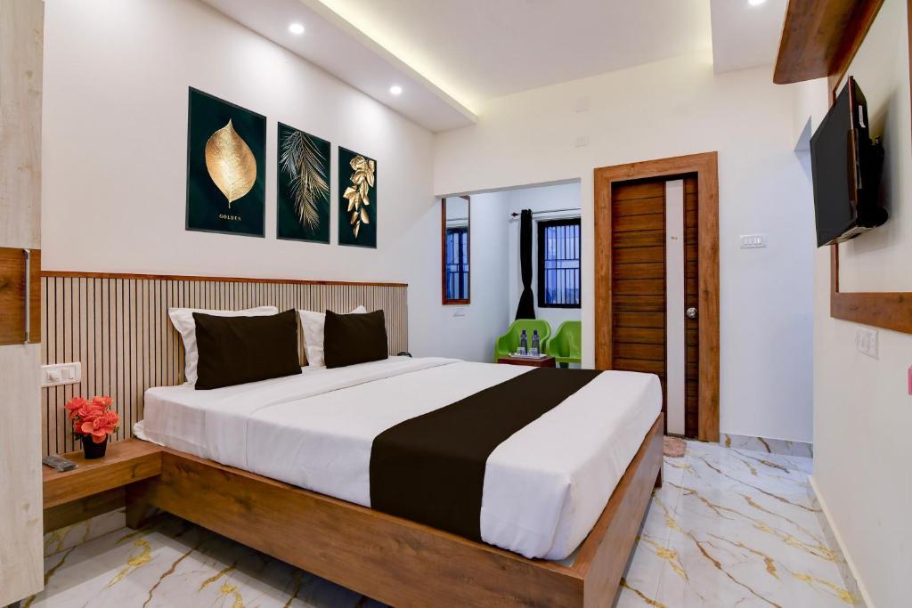 a bedroom with a large bed and a television at Super Hotel O Vitali Suites in Bhubaneshwar