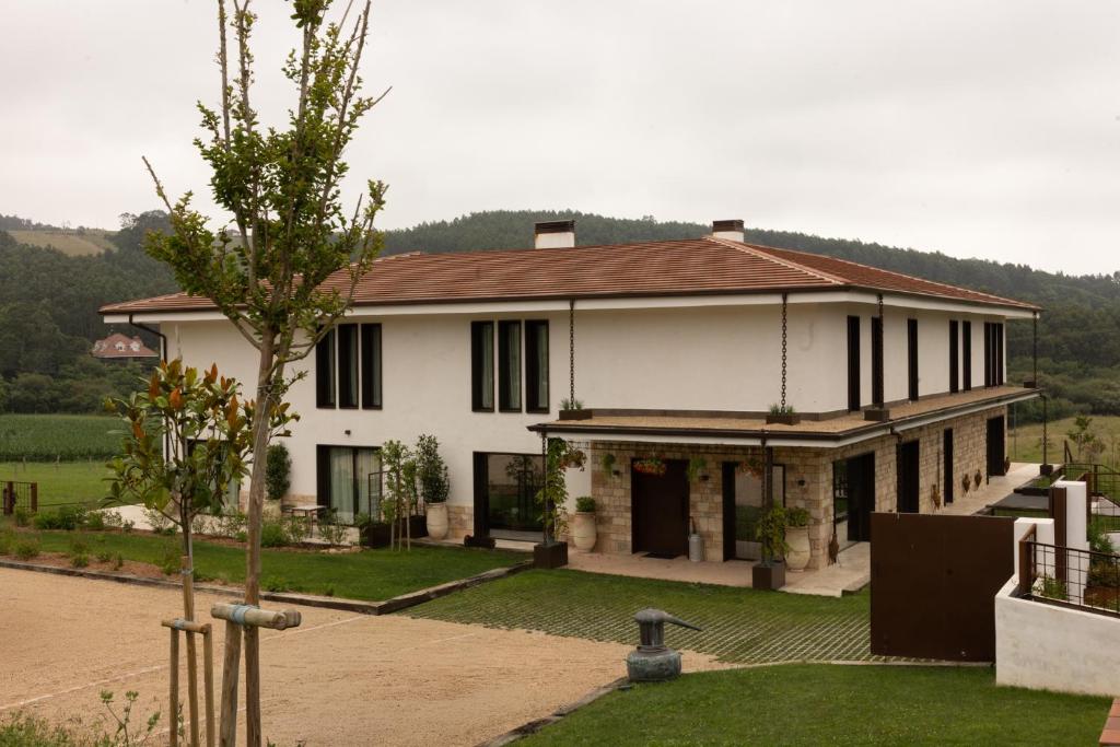 a white house with a brown roof at Kanaloa Lodge in Galizano