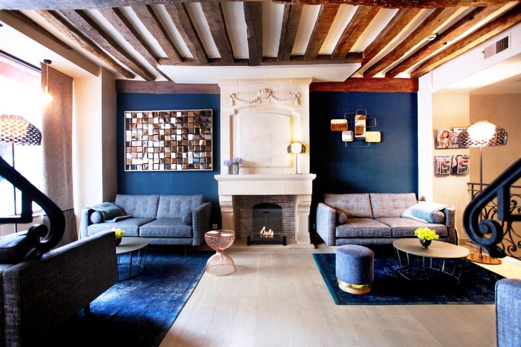 a living room with two couches and a fireplace at Hôtel Sèvres Saint Germain in Paris