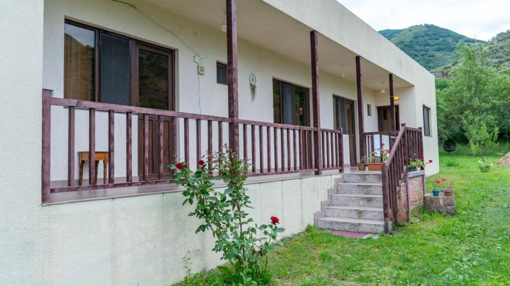 ein Haus mit einer Veranda mit Holzgeländer in der Unterkunft Bee House in Kilda