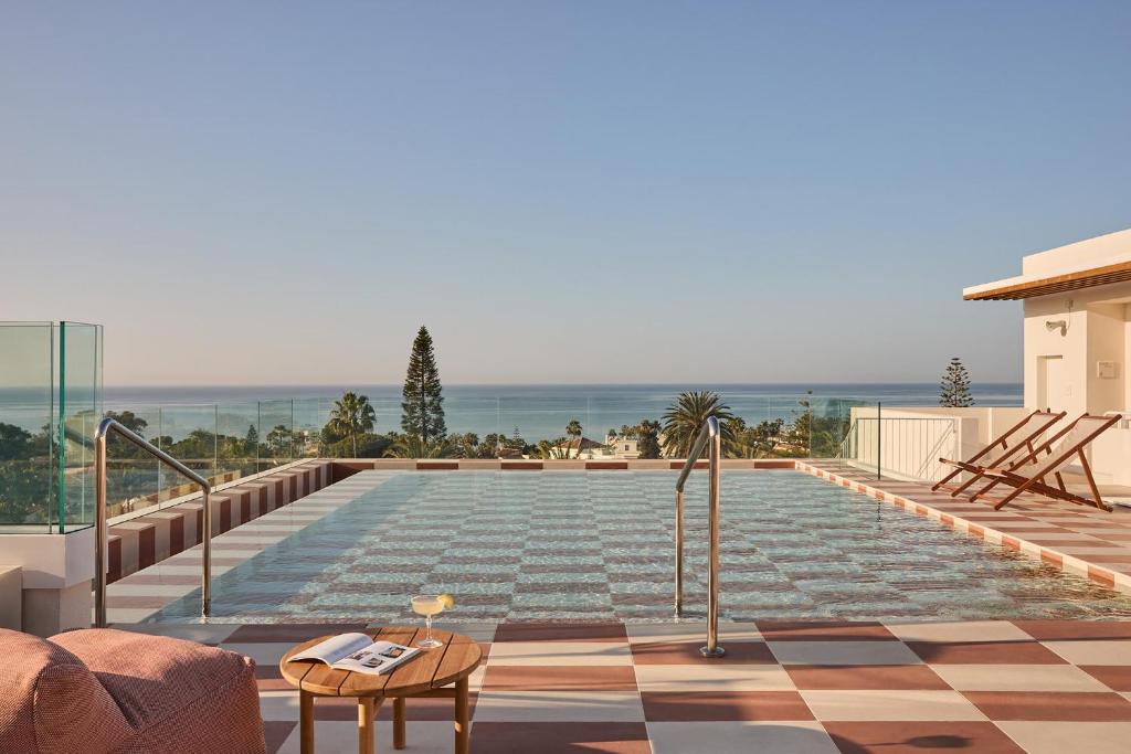 a swimming pool with a view of the ocean at Kimpton Los Monteros Marbella by IHG in Marbella