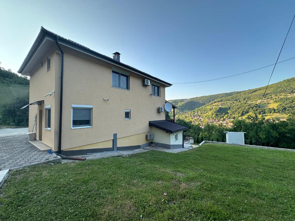 a house on a hill with a green yard at Happy House in Sarajevo