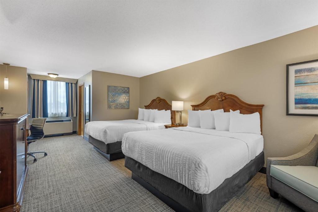 a hotel room with two beds and a desk at Best Western Plus Dubuque Hotel and Conference Center in Dubuque