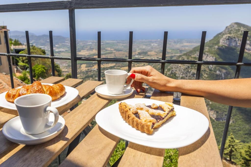 a person holding a cup of coffee with a plate of food at Annalì in Trentinara