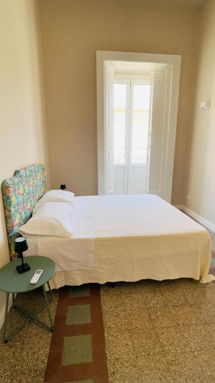 a bedroom with a large white bed and a table at Residenze Candida - Casa Bianca in Locri