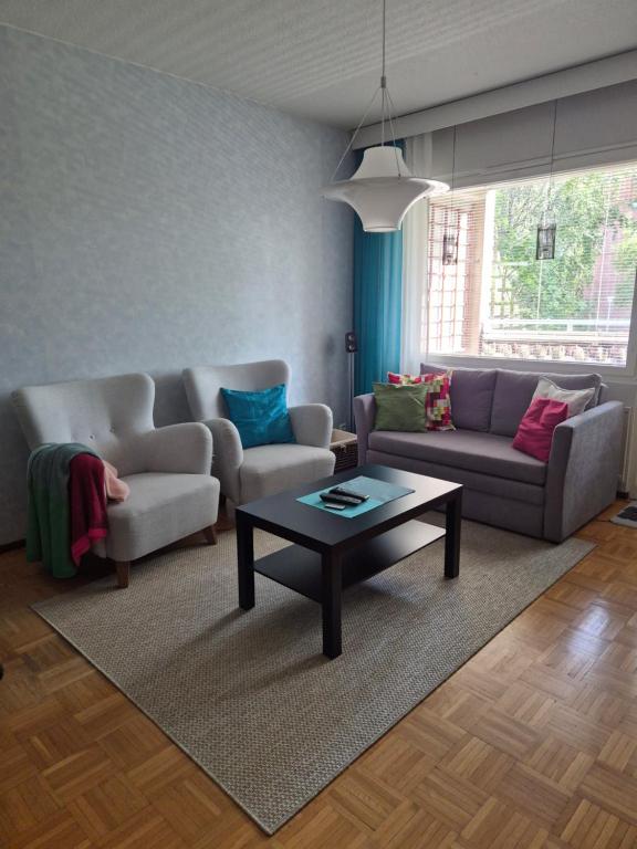 a living room with two couches and a coffee table at Apartment with private sauna in Loimaa
