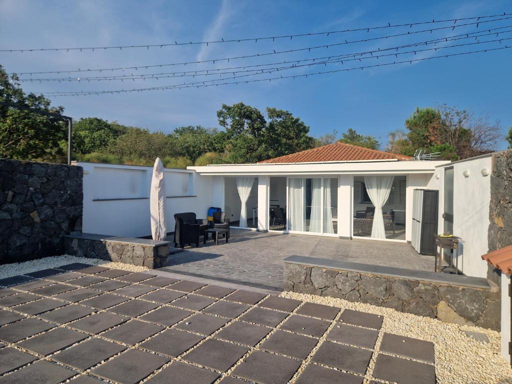 a white house with a stone patio at Villa le dalie in Mascalucia