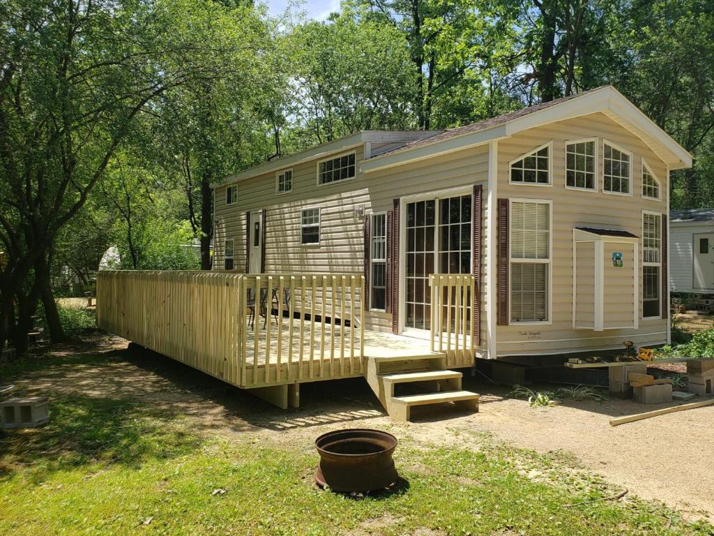 a tiny house with a porch and stairs in a yard at Baraboo RV Resort in Baraboo
