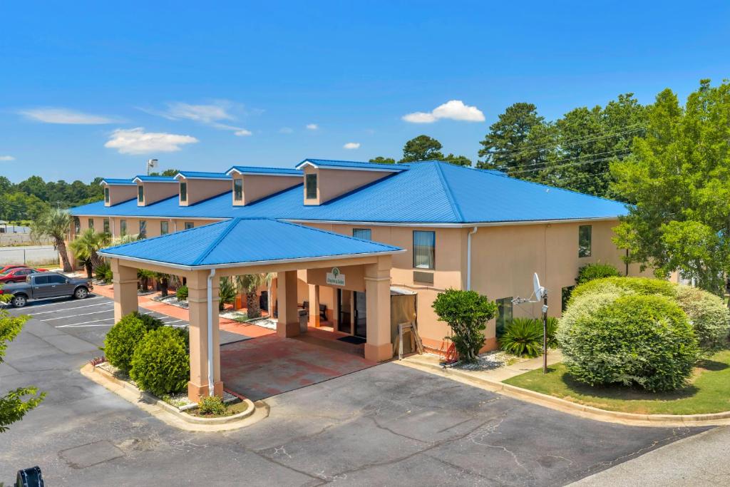 a building with a blue roof with a parking lot at Gray Inn & Suites in Gray