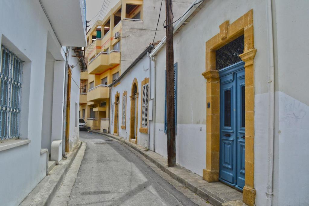 eine leere Gasse mit einer blauen Tür an einem Gebäude in der Unterkunft Chris House in Nikosia