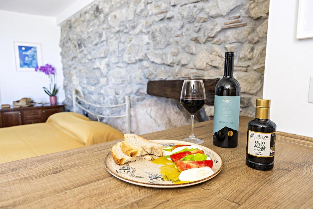 a table with a plate of food and a bottle of wine at Casa Isca in Trentinara