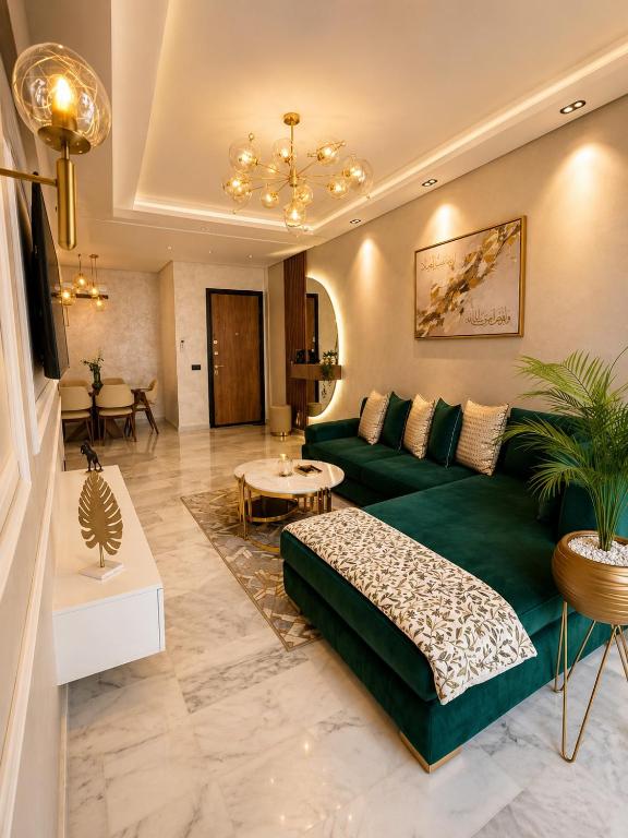 a living room with a green couch and a table at Le Jardin Secret - Pool View Elegance in Mohammedia