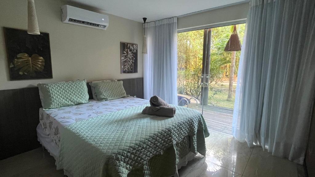a bedroom with a bed with a stuffed animal on it at Villas do Pratagy-Tulipa 1101 in Maceió