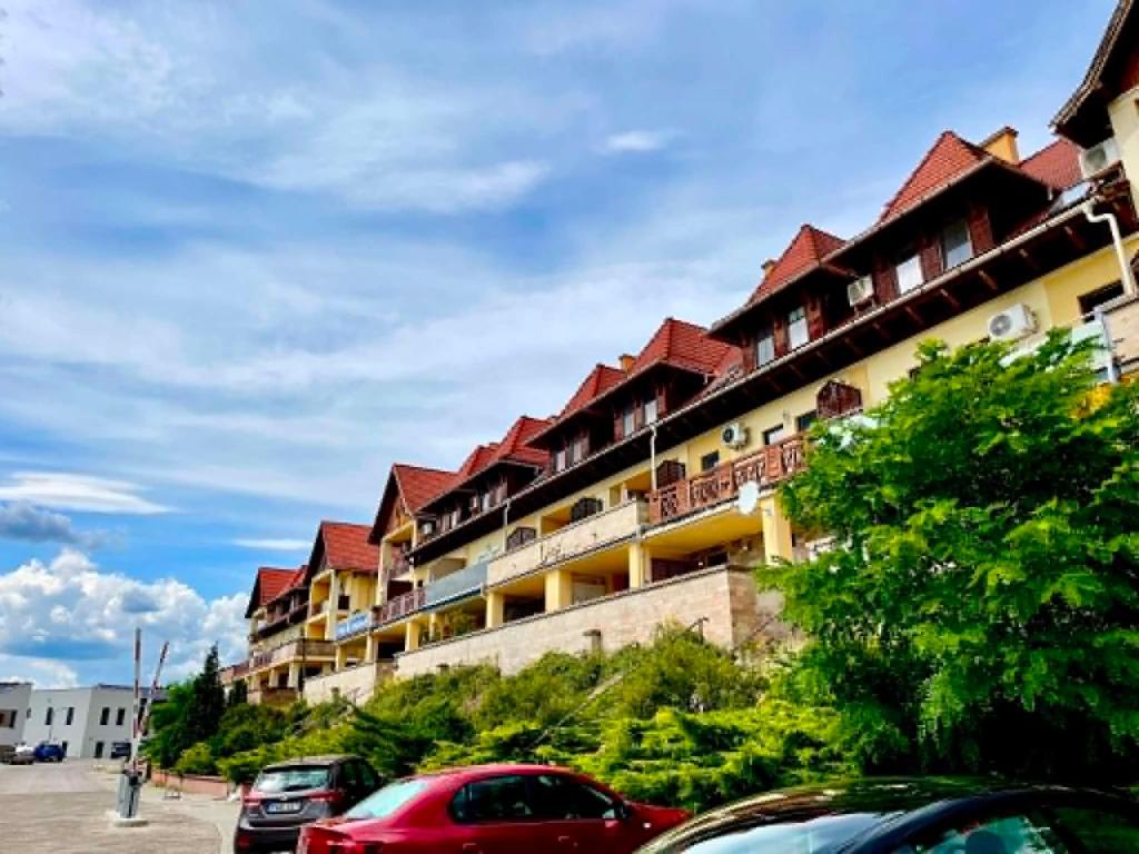 a building with cars parked in front of it at Astrum Apartman in Egerszalók