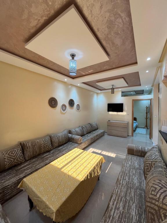 a living room with a couch and a tv at Quiet Aourire Hideway in Aourir