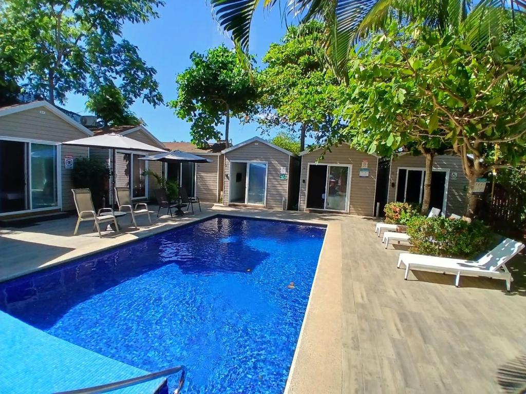 a swimming pool in the backyard of a house at Hotel Jaco Lodge in Jacó