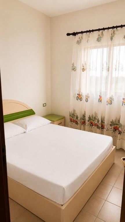 ein Schlafzimmer mit einem großen Bett und einem Fenster in der Unterkunft Hamallaj in Hamallë