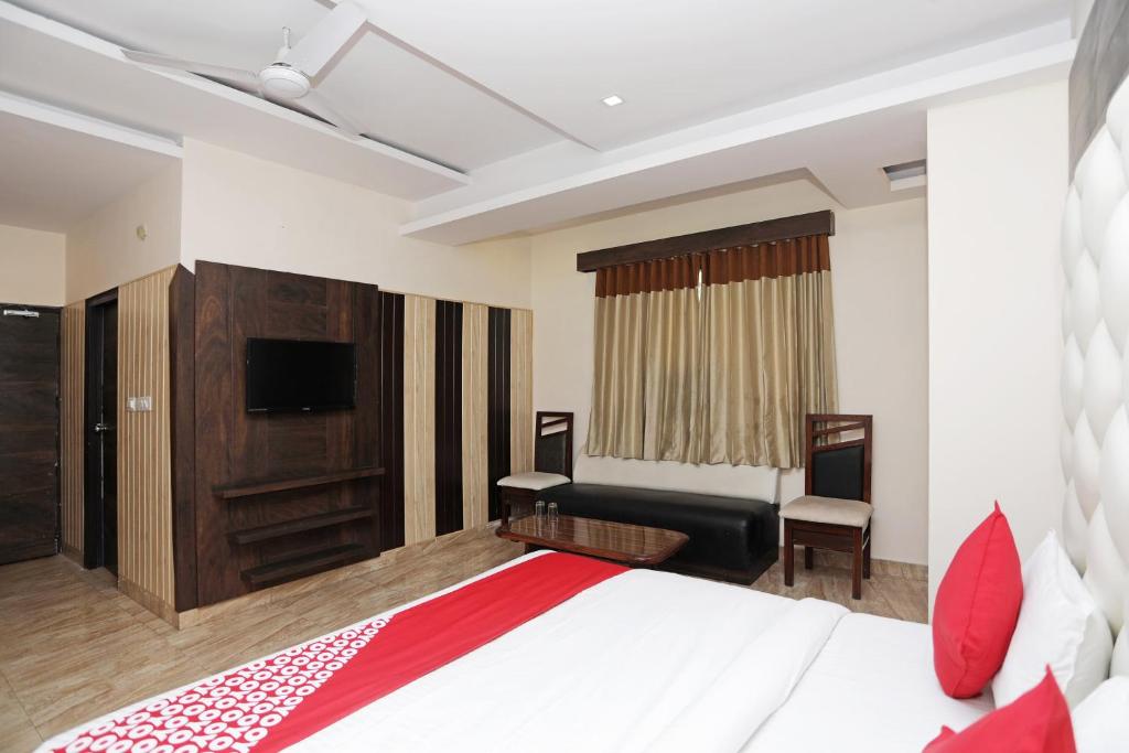 a hotel room with a bed and a tv at Hotel O Subhadra Residency in Meerut