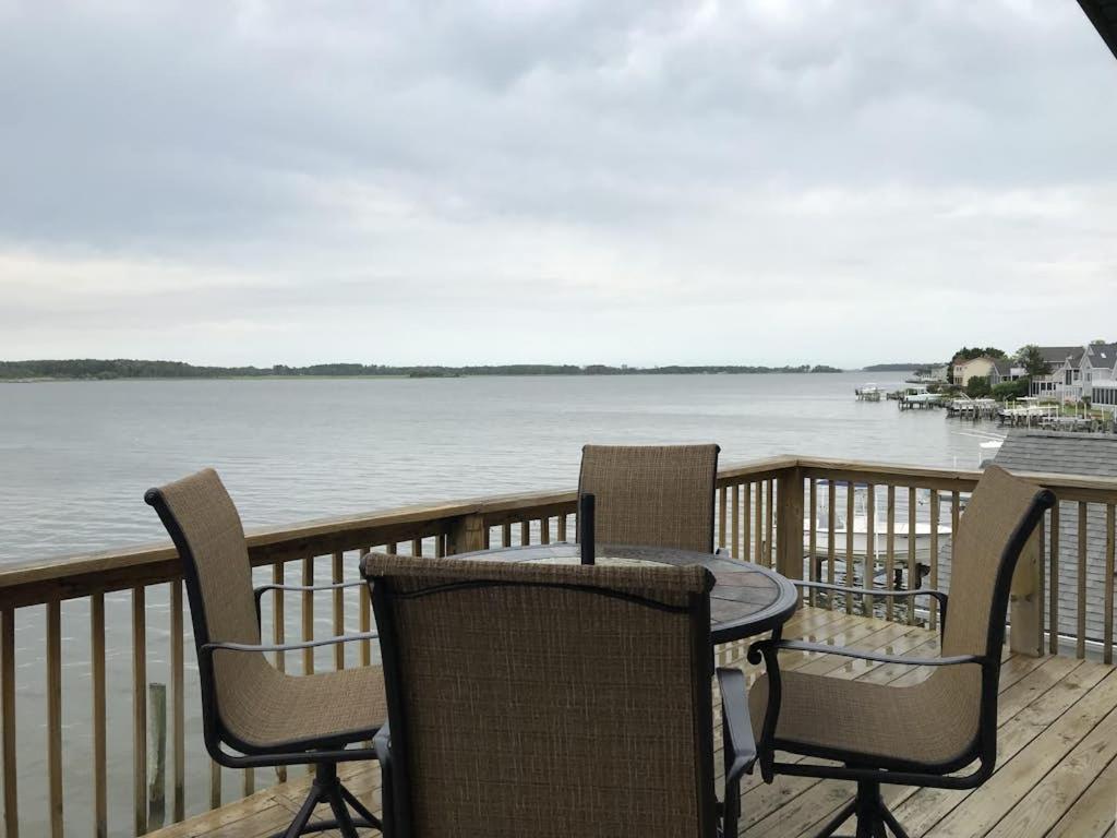 a table and chairs on a deck with the water at 14 Clipper on the Bay in Ocean Pines