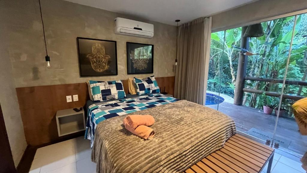 a bedroom with a bed and a large window at Villas Pratagy Flor de Lis 901-Studio in Maceió