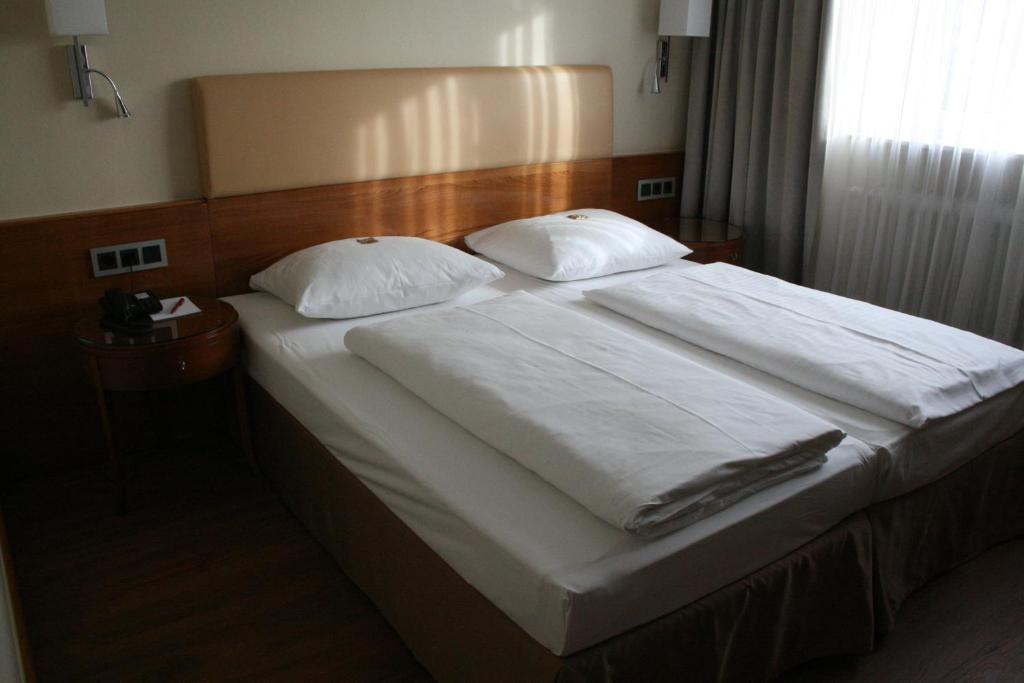 Postel nebo postele na pokoji v ubytování Dürer-Hotel