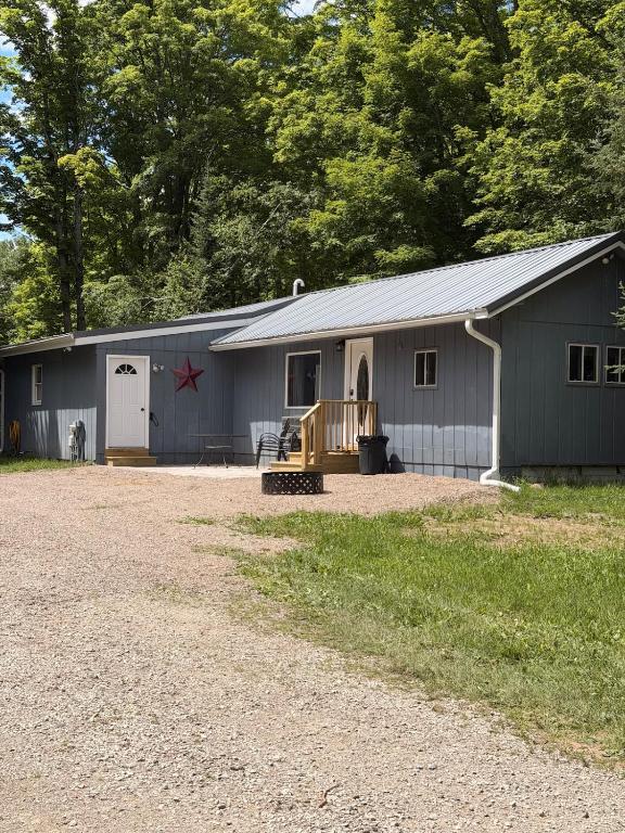 a large gray building with a garage at Maple Ridge Trail Side Cabin in Crandon